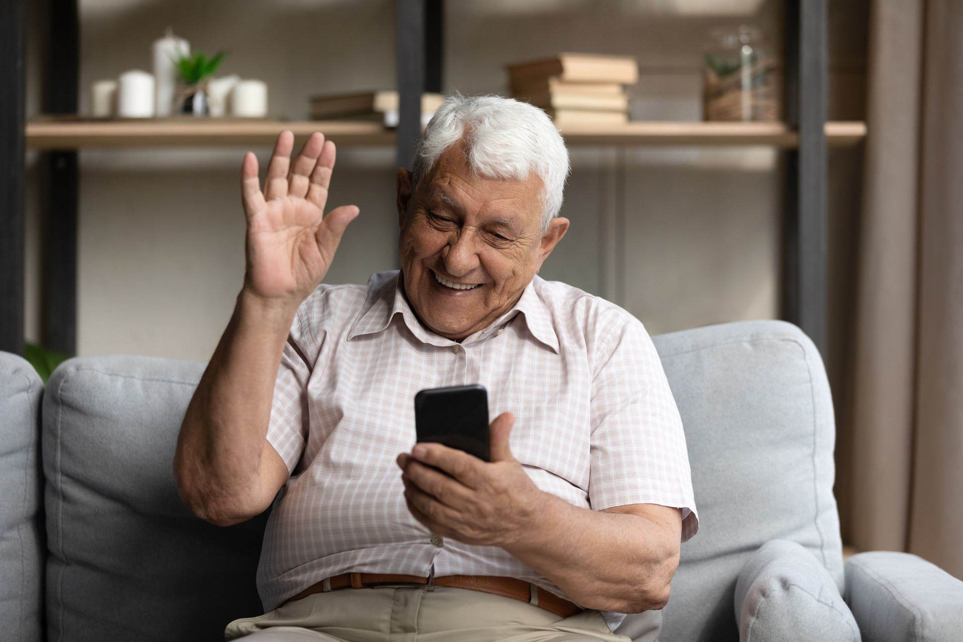 Joyeux grand-père senior des années 80 s’exprimant lors d’une vidéoconférence téléphonique