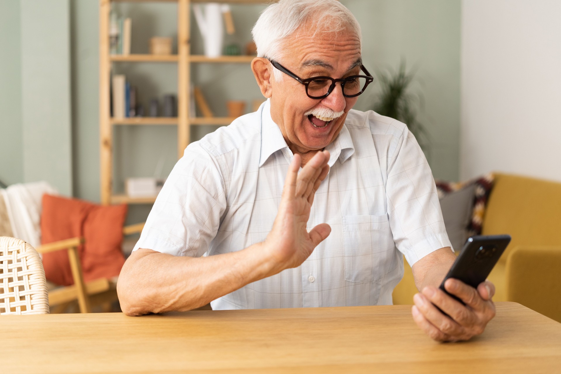 Homme mûr heureux utilisant un smartphone