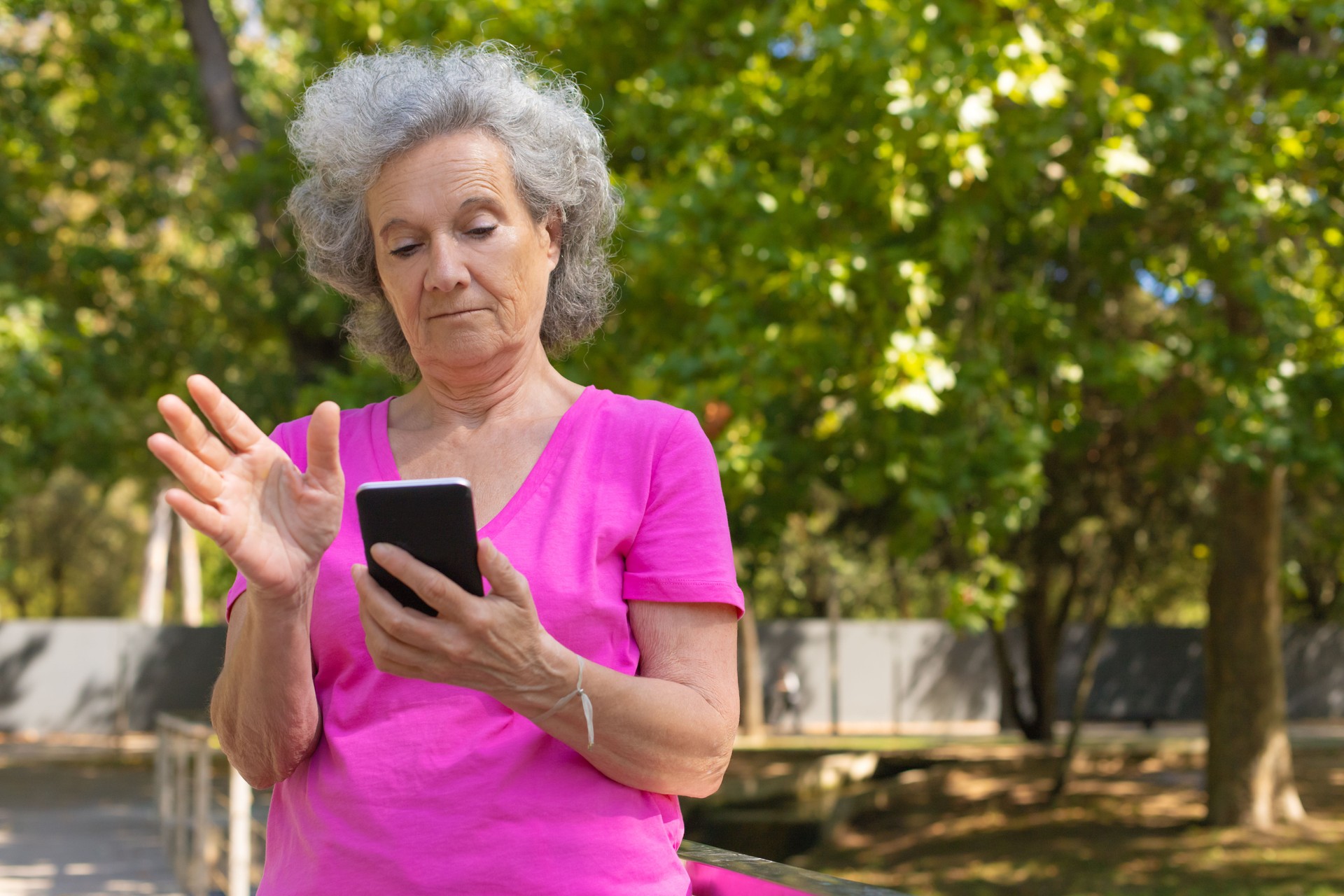Vieille dame pensive utilisant l'application mobile sur le téléphone portable